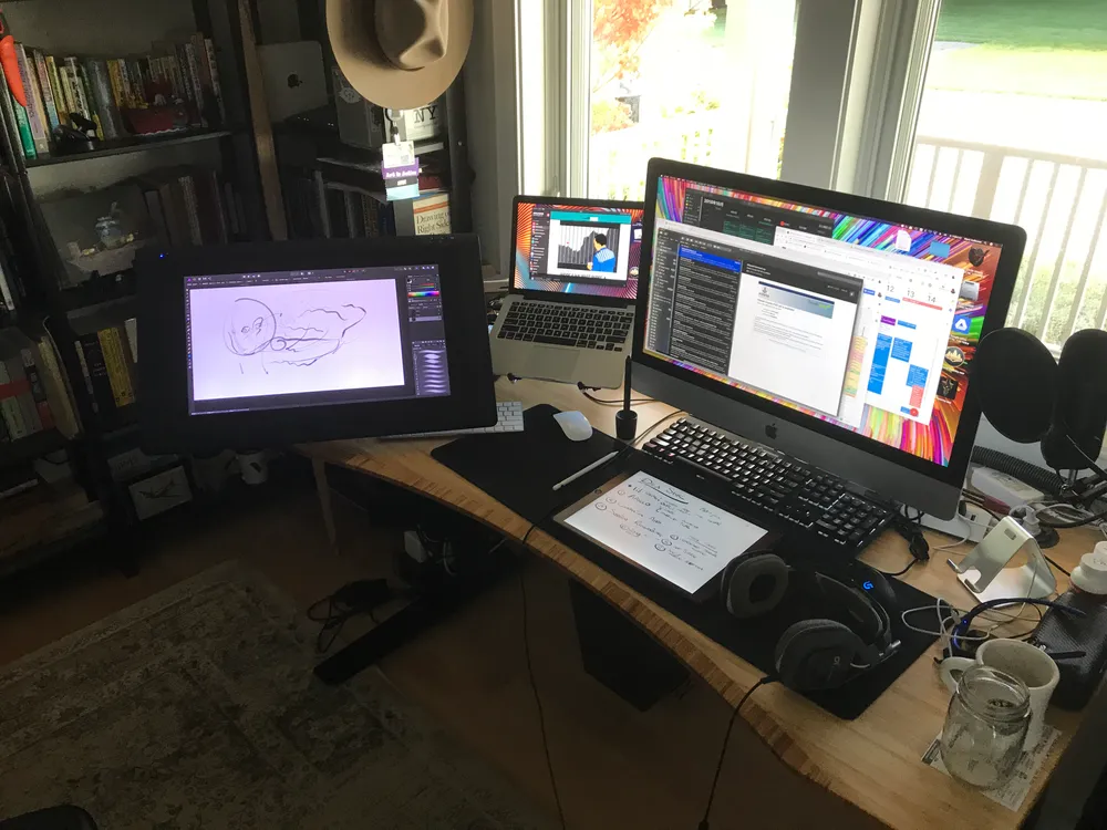 My art and work station – one of the benefits of working remotely from a home office. You can see the Wacom Cintiq 22HD on the left, and my personal MacBook Pro late 2012 13” to its right. I use the iMac 27” for work, and the iPad Pro is in the front.